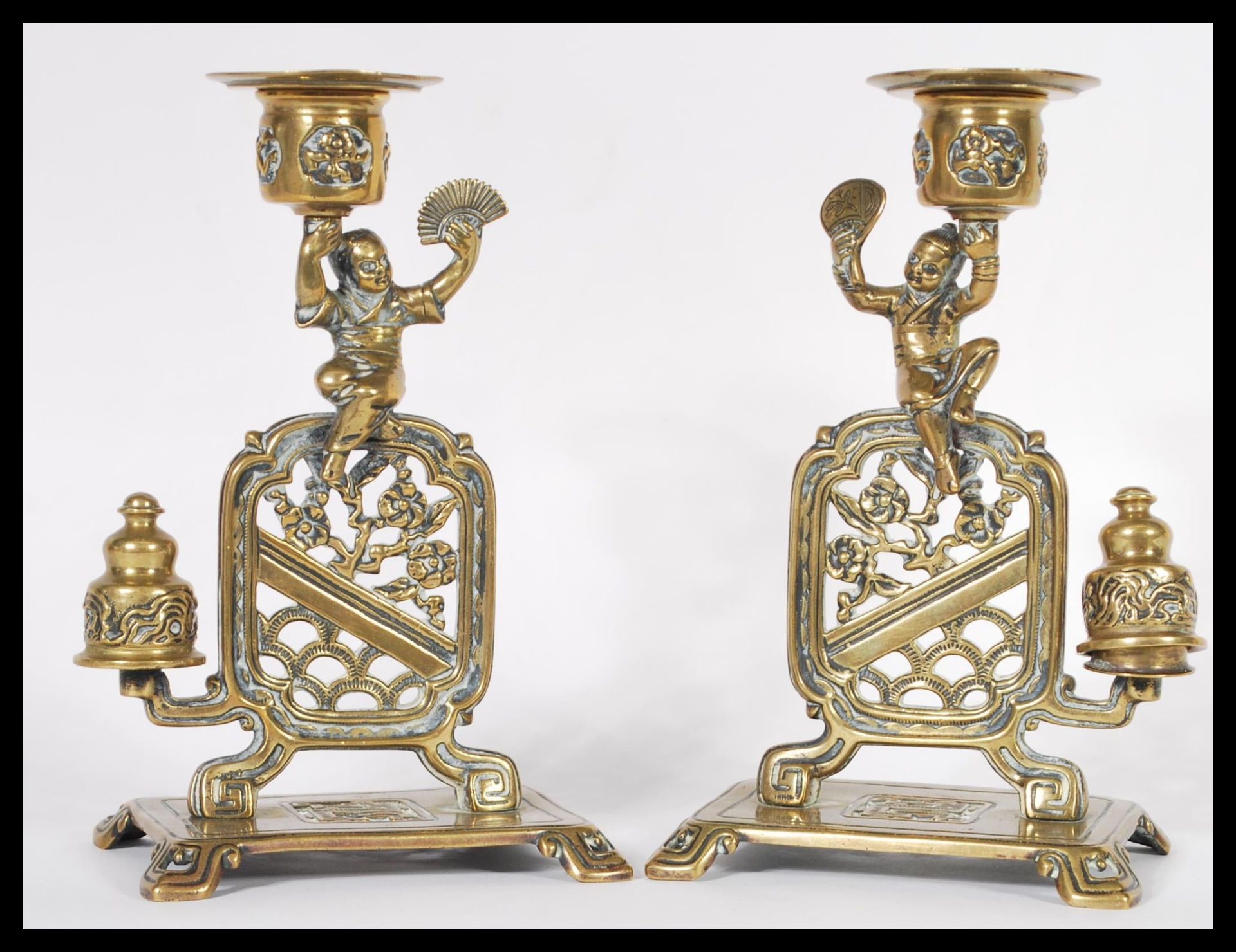 A fantastic pair of 19th Century Chinese figural bronze candlesticks raised on square bases with