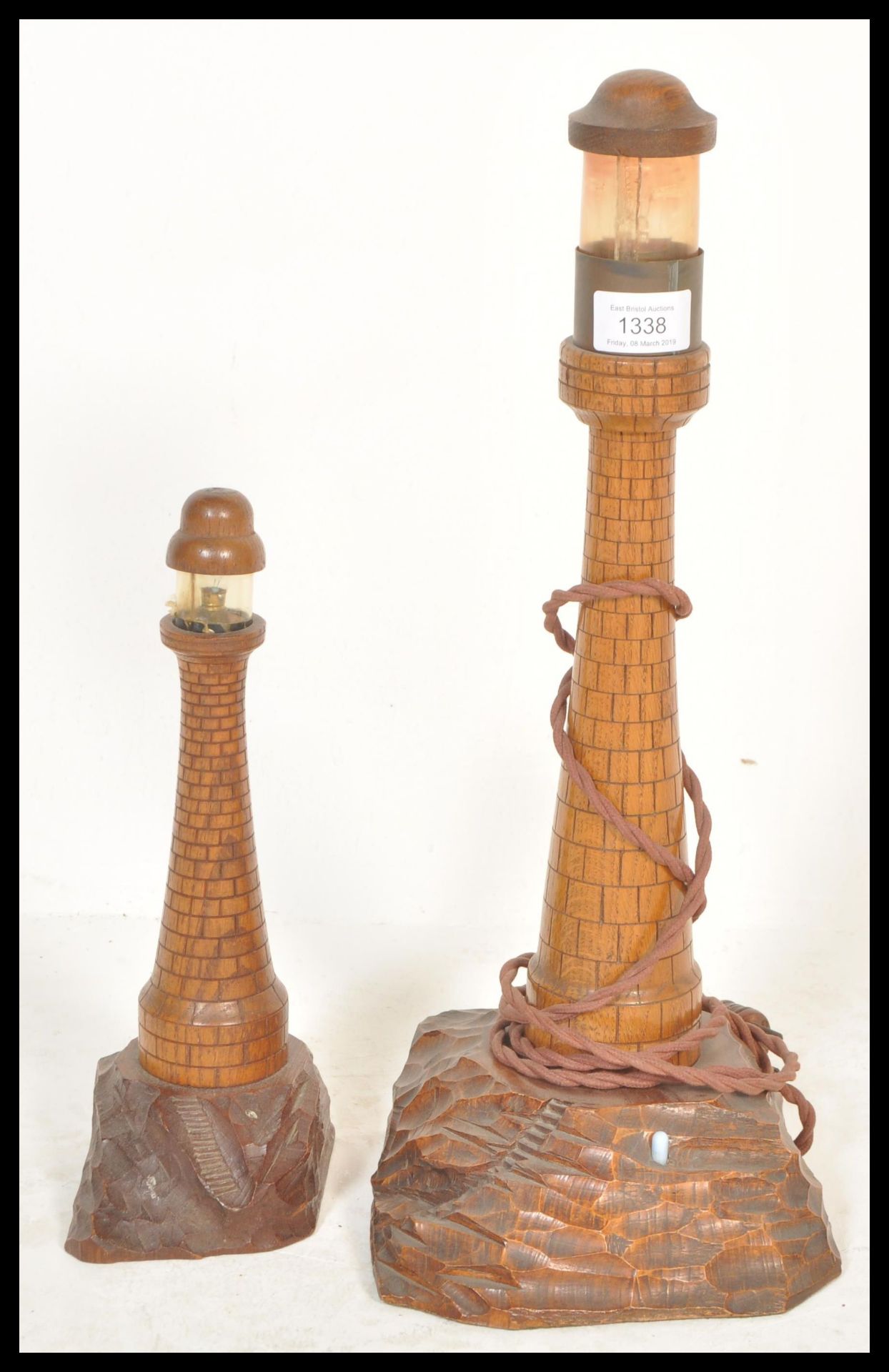 An early 20th century pair of graduating wooden Cornish table lamps in the form of a lighthouse