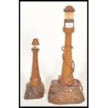 An early 20th century pair of graduating wooden Cornish table lamps in the form of a lighthouse