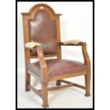 A 20th Century oak judges or judge arm chair having red leather upholstery and a domed top back