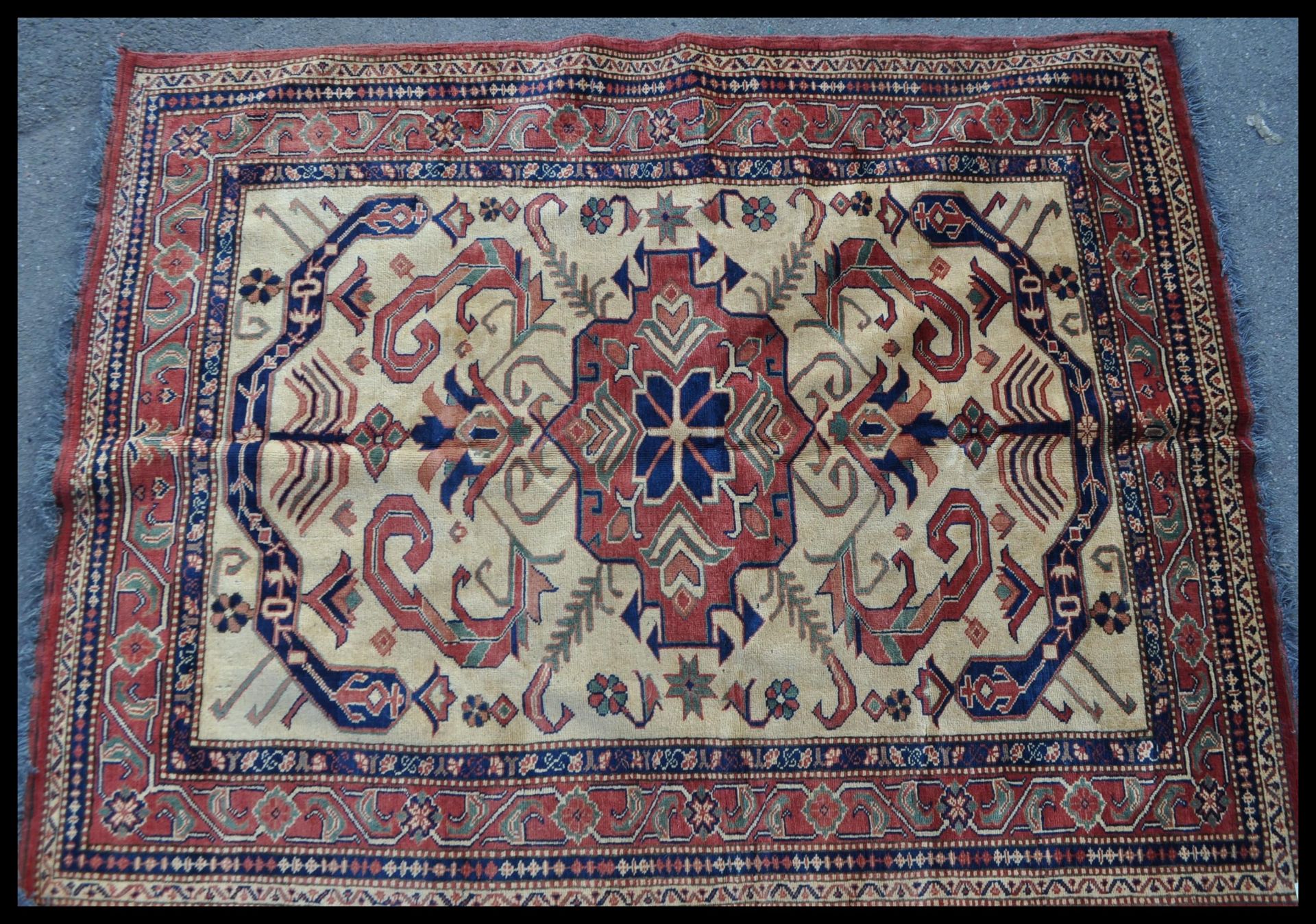 A 20th Century hand knotted Afghan carpet rug having a red ground with a central yellow panel with