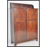 An early 19th Century flame mahogany bookcase cabinet having scrolled gallery top with brass lined