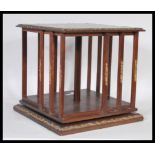 An early 20th Century Edwardian mahogany table top revolving bookcase, open slatted sides with