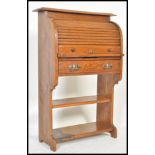 An early 20th Century Arts & Crafts oak students tambour fronted bureau, with shelf and a fall front