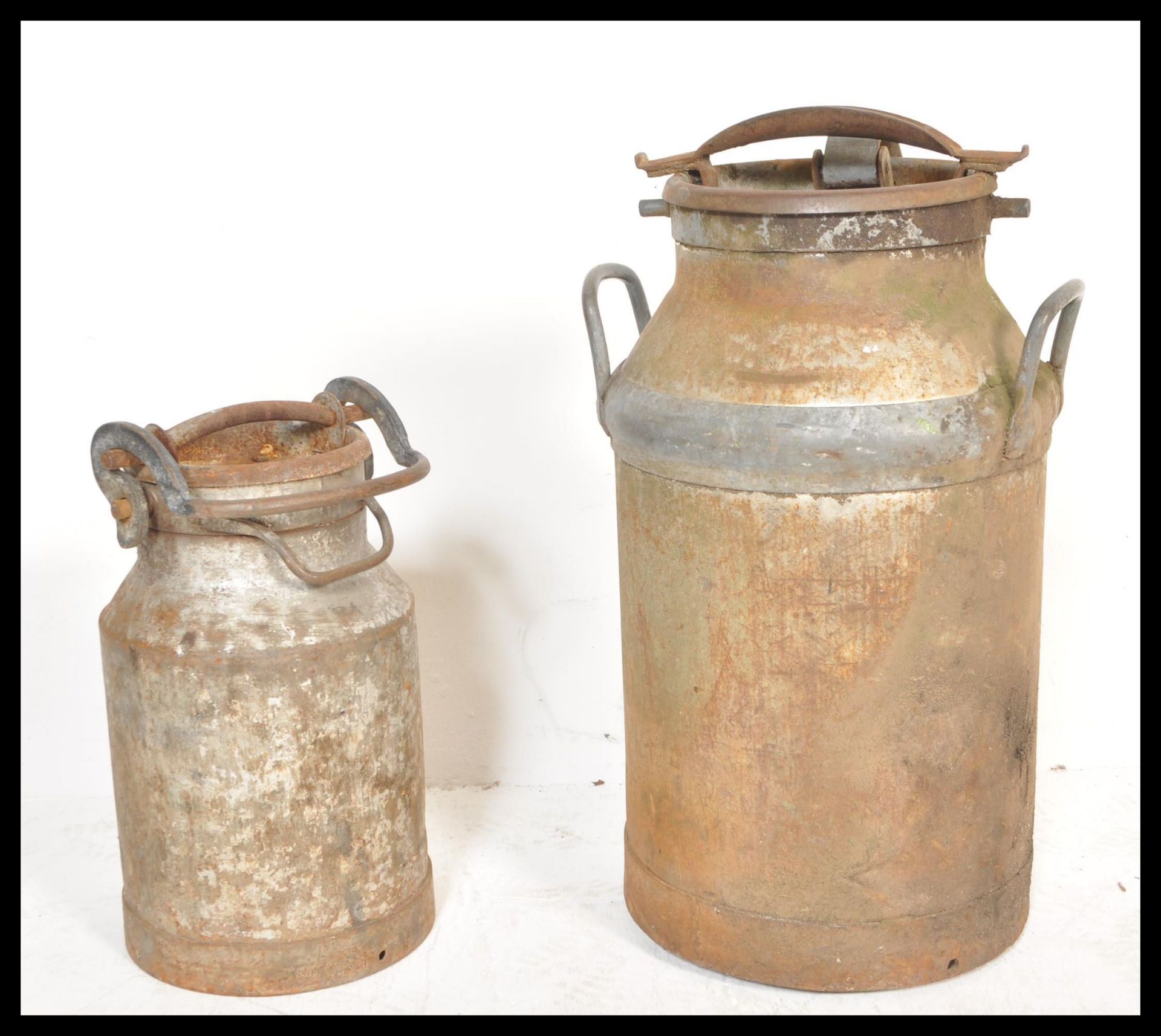 Two vintage 20th Century galvanised metal milk churns complete with lids and clasps.