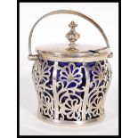 An early 20th Century hallmarked silver large jam or condiment pot having original blue glass liner.