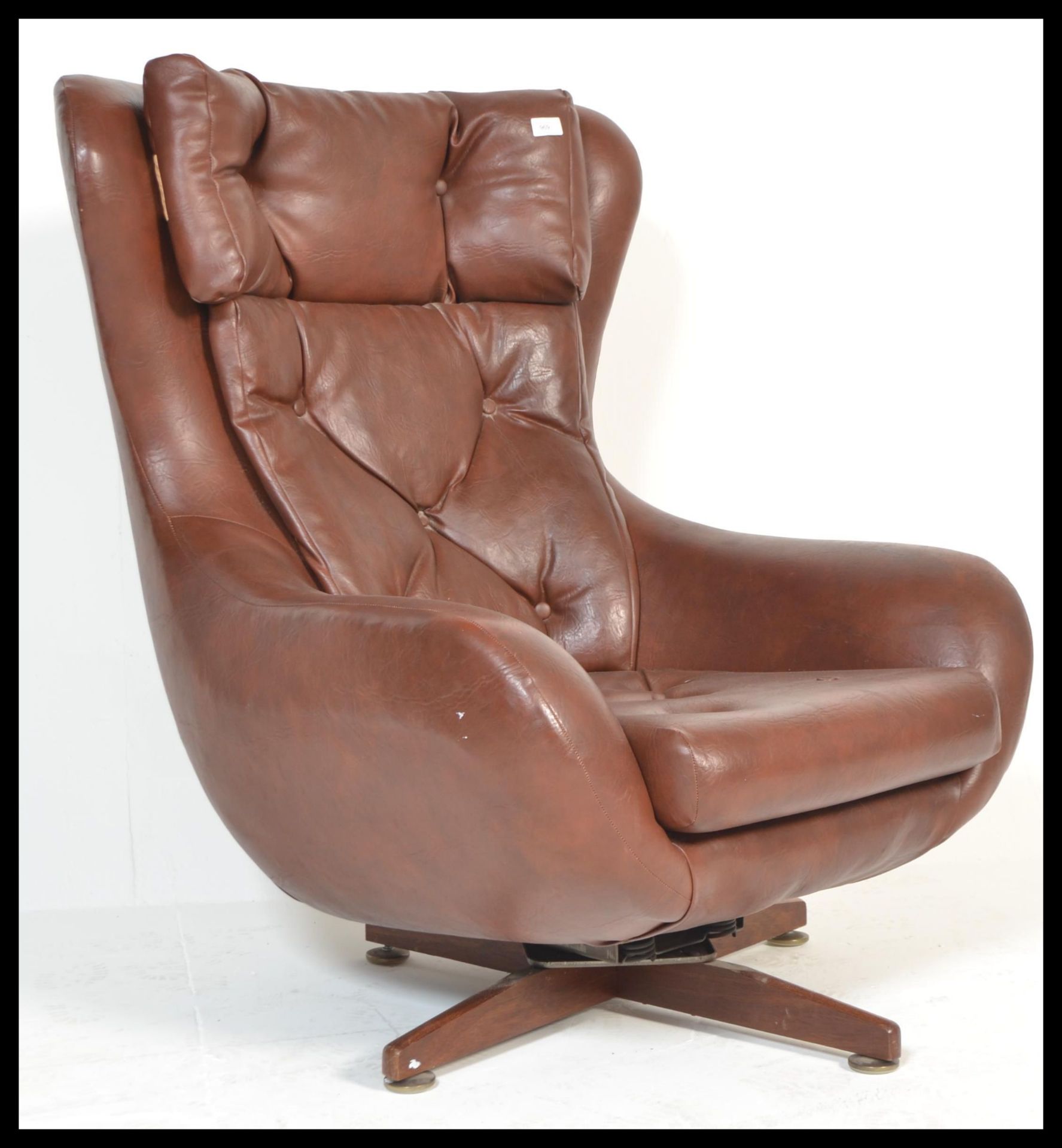 A retro / vintage 20th Century Parker Knoll Statesman swivel easy chair, upholstered in a tan button