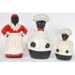 A collection of three cast metal Negro money boxes in the form of jolly fat chef's and a cook. All