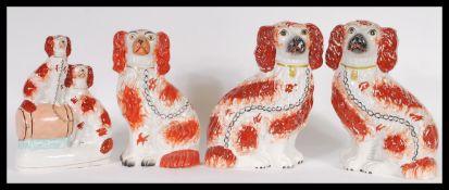 A pair of 19th Century Staffordshire fireside figurines of Spaniels together with another two