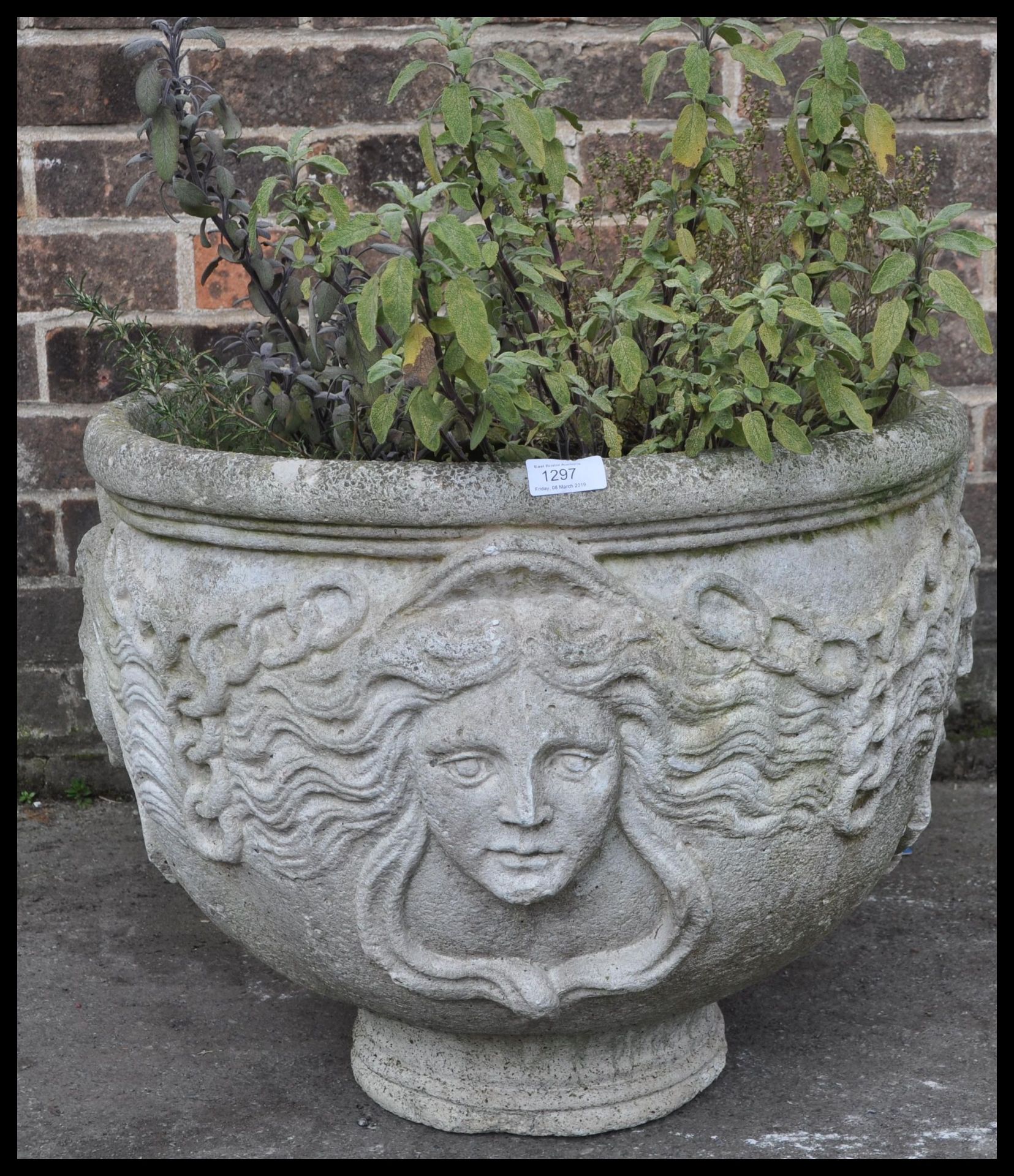 A vintage 20th century antique style reconstituted garden stone, the planter having human face