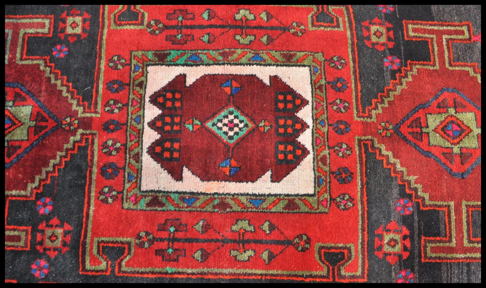 A Persian Islamic tribal Bakhtiari hand made wool rug / floor carpet having a red ground with - Bild 2 aus 4