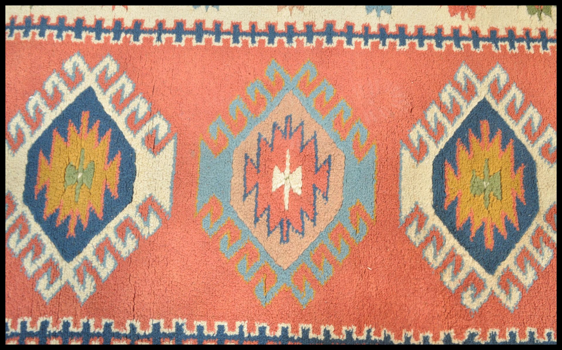 A 20th Century woven tribal carpet rug having a cream ground with a central red panel with three - Bild 2 aus 4