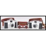 Two vintage retro Agfa Silette Vario film cameras in fitted brown leather cases, along with a pair