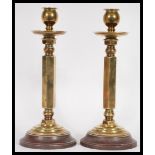 A pair of early 20th Century fine quality heavy brass candlesticks raised on stepped circular