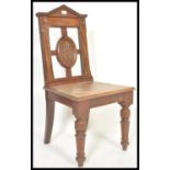 A Victorian 19th century solid mahogany hall chair raised on turned legs with solid panel seat