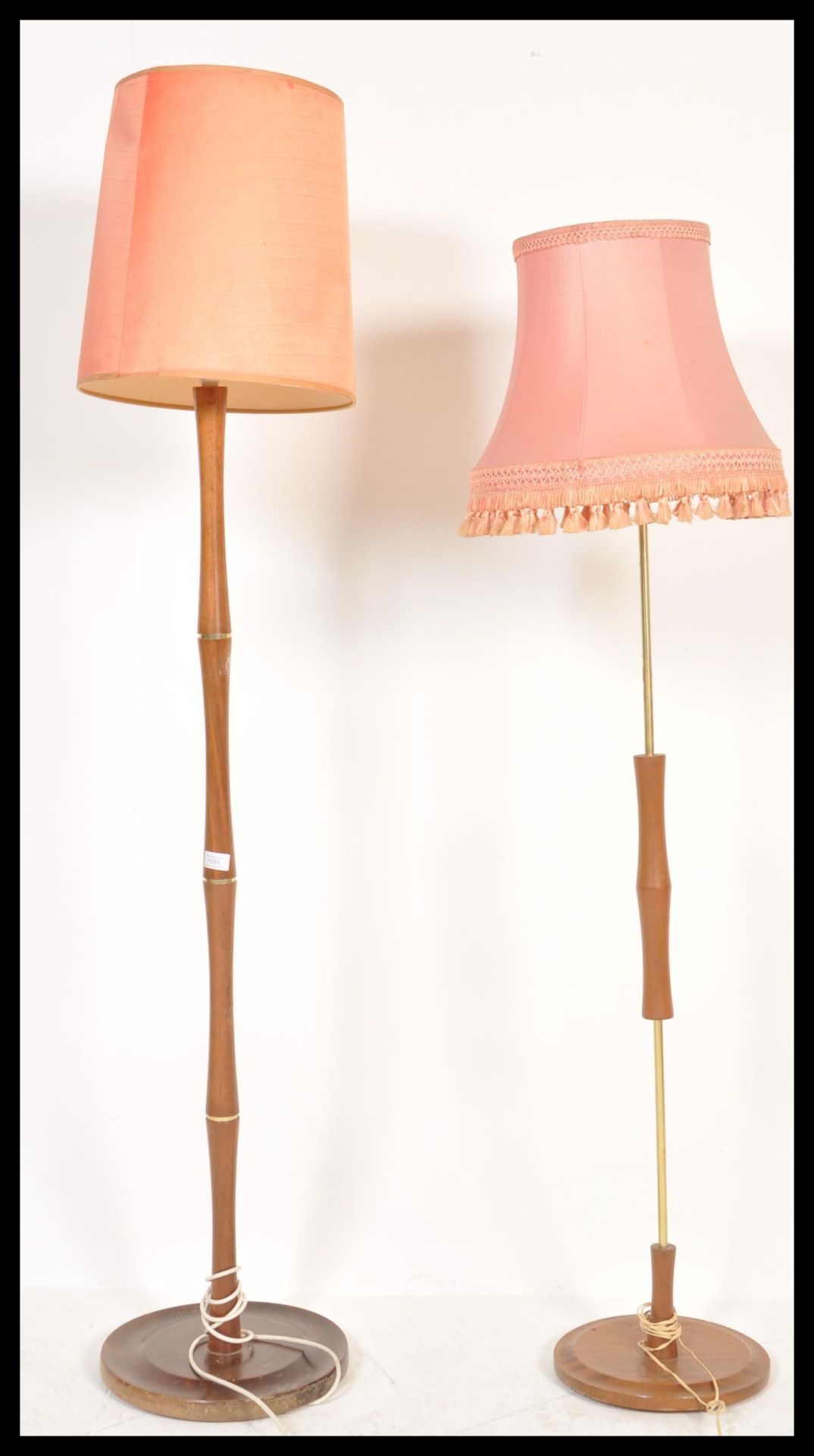 A 1970's teak wood standard lamp raised on terraced base with turned column and tapering shade