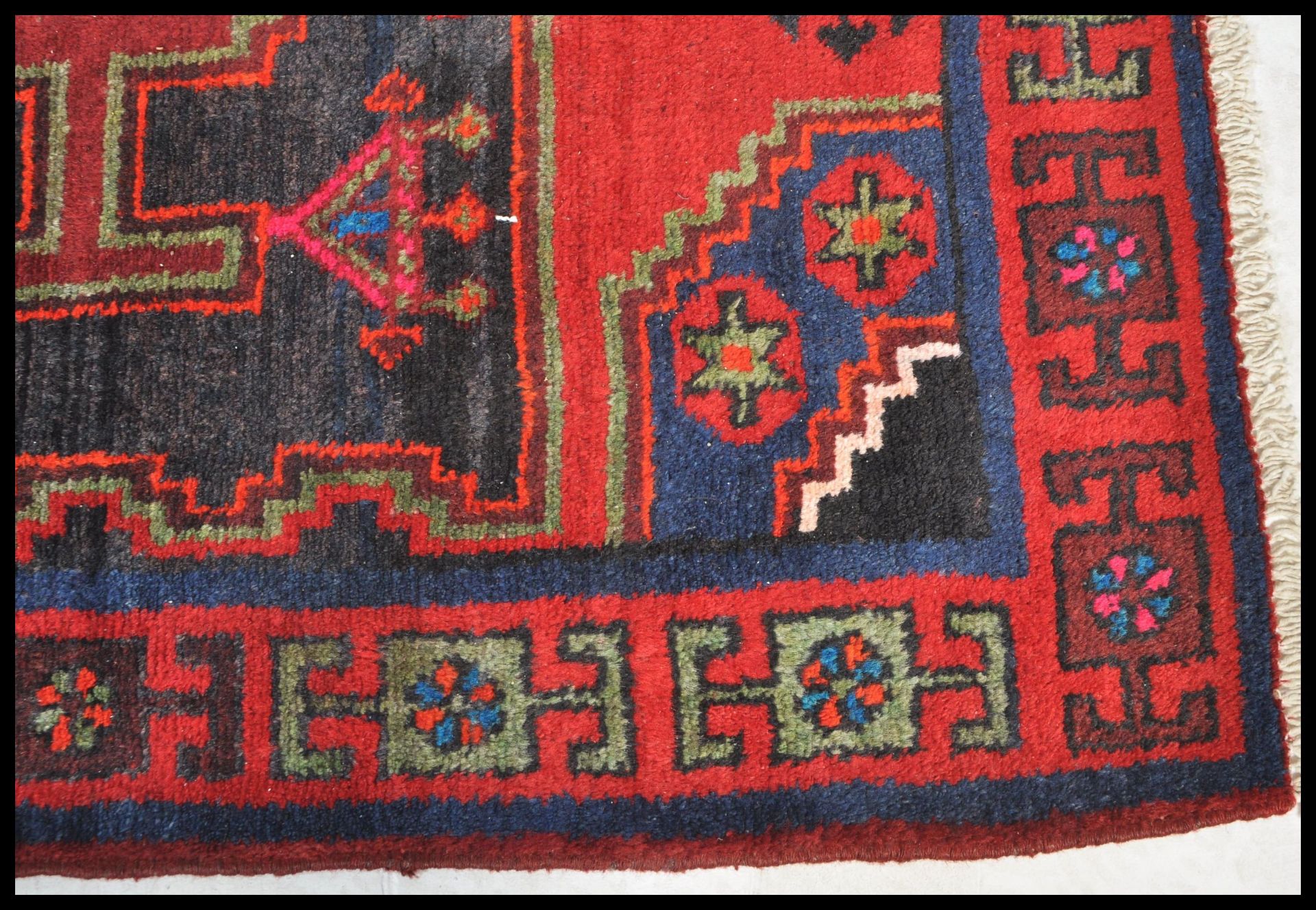 A Persian Islamic tribal Bakhtiari hand made wool rug / floor carpet having a red ground with - Bild 3 aus 4