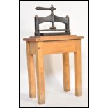A 19th Century Victorian cast iron book press of typical form raised on a solid oak frame / stand