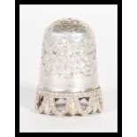 A early 20th century silver hallmarked thimble, having engraved decoration with pierced rim to