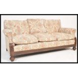 A 1920's Chesterfield 3 seat sofa settee being raised on bun feet with castors having barrel arms