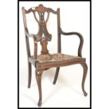 An early 20th Century inlaid mahogany elbow chair, with pierced fan slat back, shaped arms with