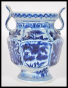 A 20th Century Chinese blue and white hand painted vase of hexagonal form having cartouche panels