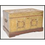 A 19th Century Zanzibar brass studded and armorial decorated trunk chest having large brass panel