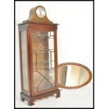 A 1930's dome top mantel clock with silvered dial together with a mahogany oval overmantel mirror