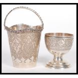 Two pieces of early 20th Century Middle Eastern silver to include an egg cup raised on stepped