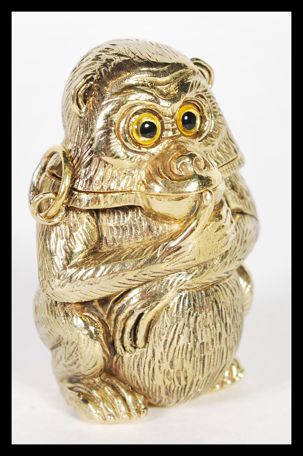 A brass novelty vesta case in the form of a monkey deep in thought.