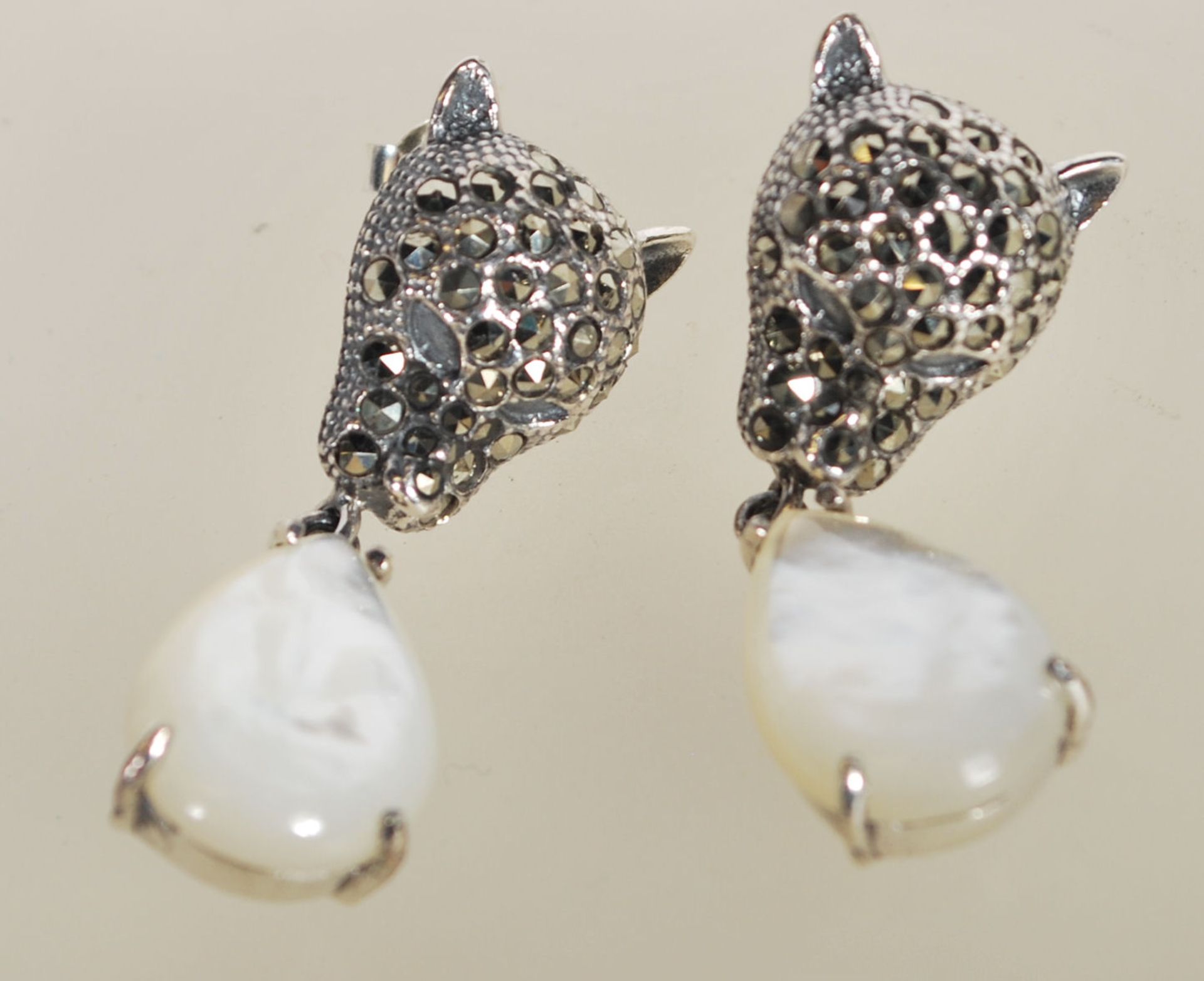 A pair of sterling silver and marcasite decorated designer earrings in the form of panthers having