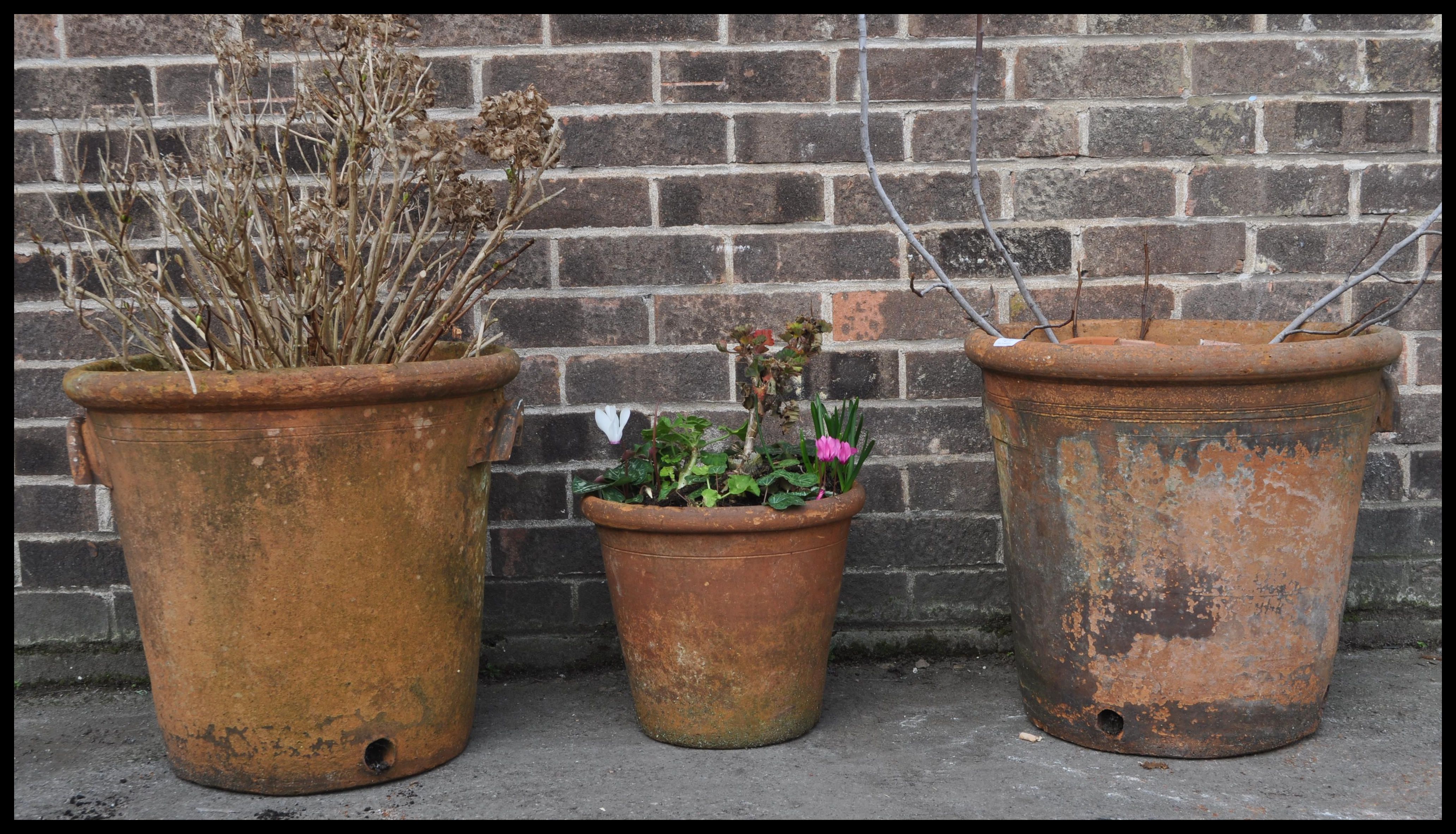 A collection of three 20th century garden terracotta plant pots in red colour. The  large pair