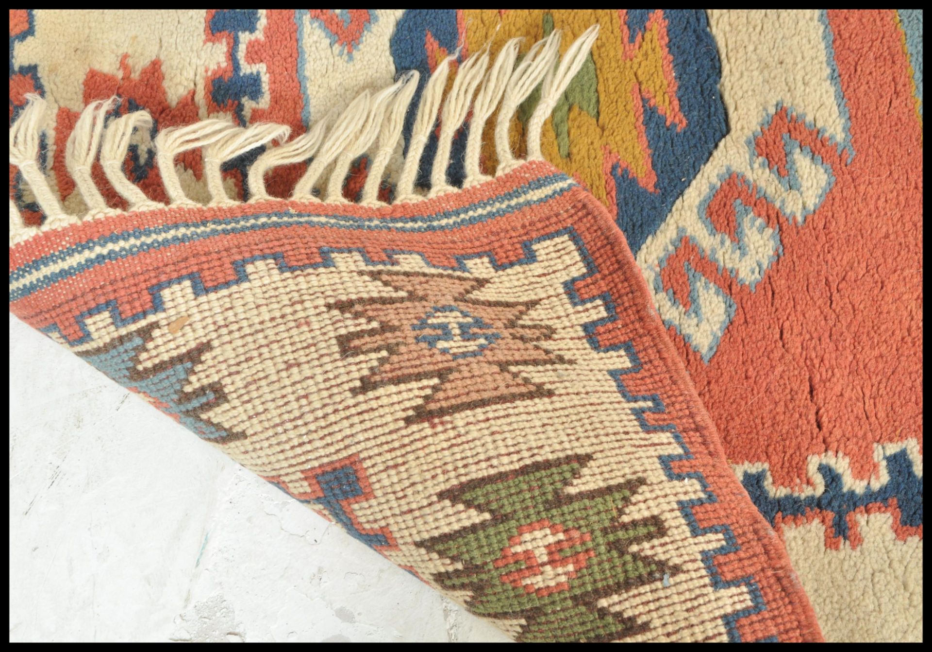 A 20th Century woven tribal carpet rug having a cream ground with a central red panel with three - Bild 4 aus 4