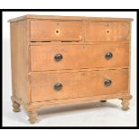 A Victorian pine 2 over 2 cottage chest of drawers being raised on turned legs with 2 short