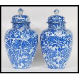 A pair of early 19th Century Chinese late Qing Dynasty large blue and white jars / vases and covers.