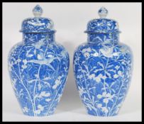 A pair of early 19th Century Chinese late Qing Dynasty large blue and white jars / vases and covers.