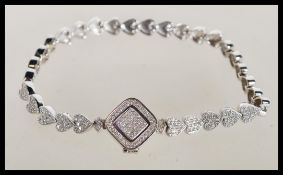 A sterling silver bracelet having heart shaped links decorated with CZ stones. Weighs 14 grams.