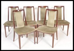 A set of 1970's retro dark teak wood G-Plan style dining chairs being raised on squared legs with