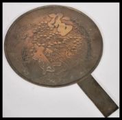 A 19th Century Japanese bronze hand mirror having decoration depicting character marks, birds and
