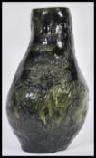 A 20th Century studio pottery heavy lamp base having a green glaze with incised decoration depicting