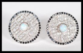 A pair of sterling silver CZ and opal panelled stud earrings of circular form having central opal