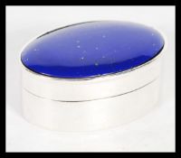A sterling silver large pill box of oval form having inset lapis lazuli cabochon lid. 27 grams.