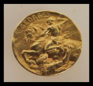 An 18ct gold French medallion of St Georges marked Becker having St George slaying the dragon and