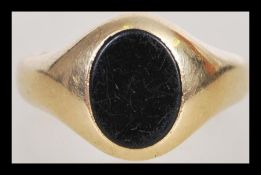 A 9ct gold hallmarked signet ring set with a black oval stone. Hallmarked Birmingham 1961. Total