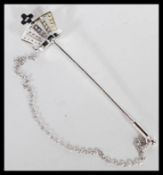 A sterling silver hat pin in the form of a crown decorated with CZ stones. Weighs 4 grams.