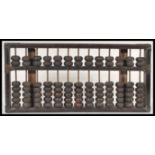 A 19th century Chinese abacus of typical beaded form, the top with applied brass supports to the