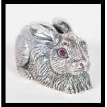 A sterling silver figurine in the form of a rabbit or hare having faceted red stone eyes. Weighs