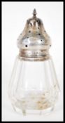 An early 20th Century silver hallmarked topped sugar shaker or caster having a faceted glass body