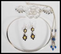 A selection of silver jewellery to include a flat collar necklace, a floral pendant set with white