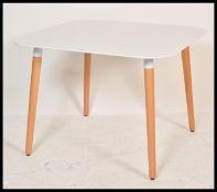A contemporary white laminated and ash dining table. The table comprising of a laminated wooden